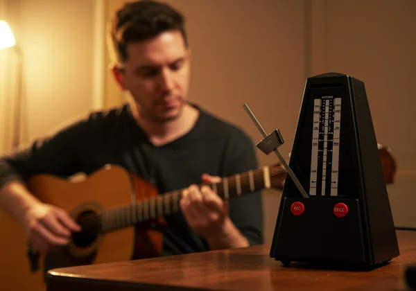 Musician practicing with a digital metronome for rhythm