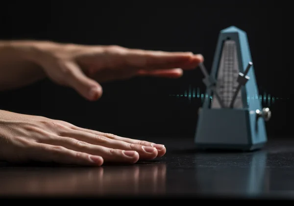 Hands tapping complex rhythmic subdivisions with metronome